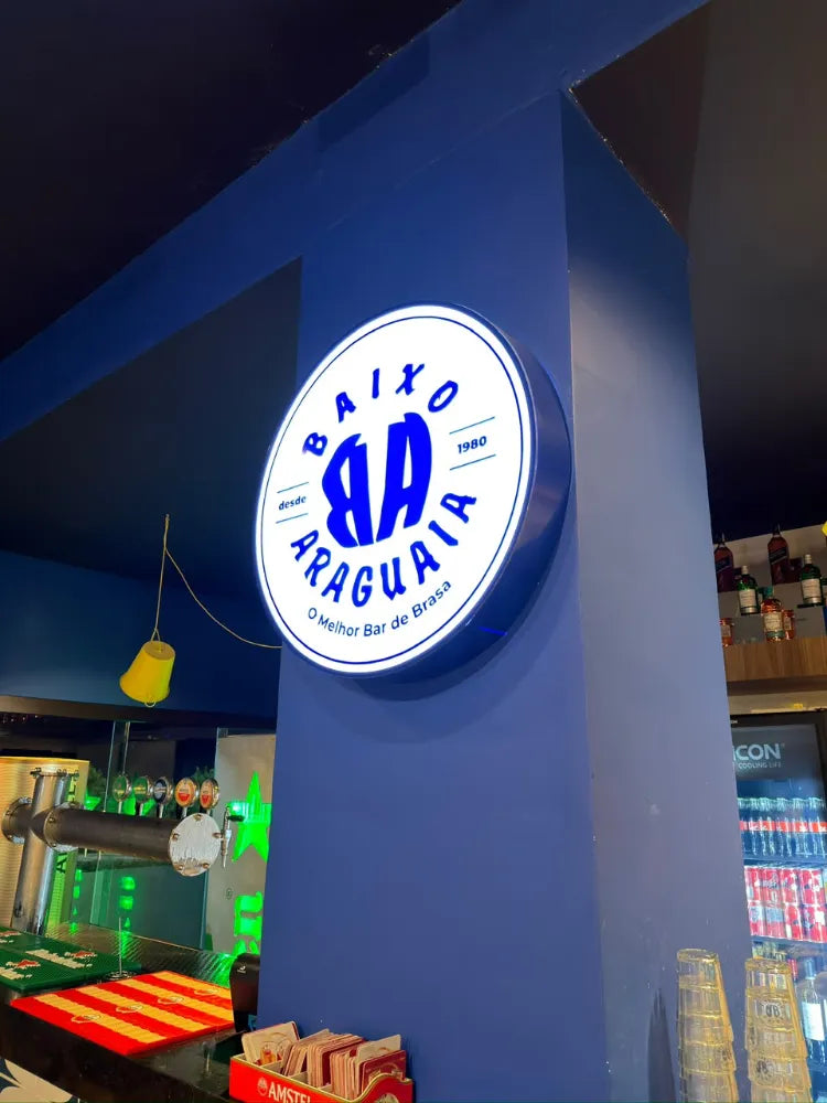 Letreiro circular iluminado em fachada comercial